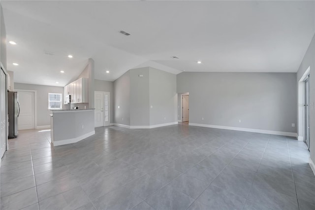 33 Peterlee Ct, Kissimmee, FL 34758 - unfurnished living room with light tile patterned flooring, vaulted ceiling, and recessed lighting