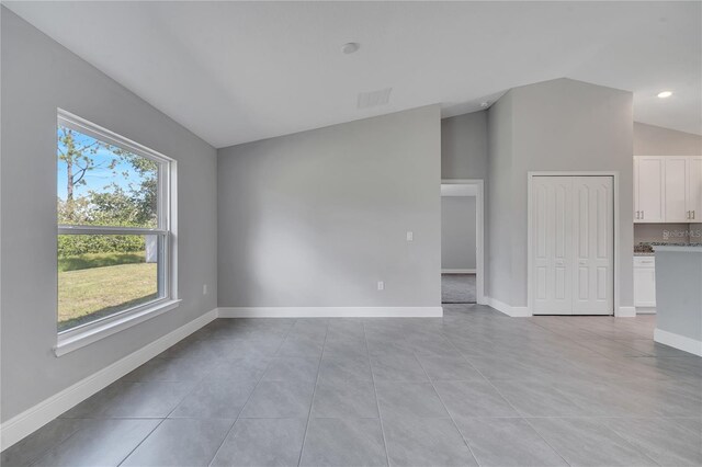 33 Peterlee Ct, Kissimmee, FL 34758 - spare room with vaulted ceiling and light tile patterned flooring