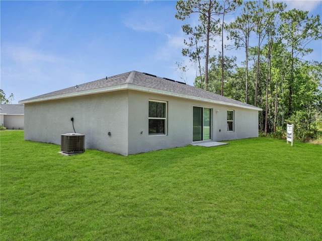 33 Peterlee Ct, Kissimmee, FL 34758 - rear view of property featuring a yard, stucco siding, and roof with shingles