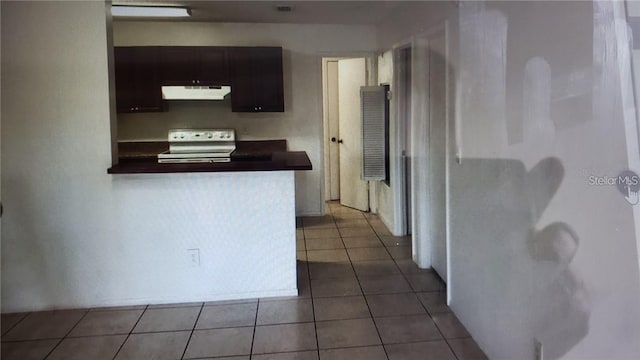 2002 Cascades Blvd Unit 108, Kissimmee, FL 34741 - kitchen featuring ventilation hood, range with electric stovetop, dark countertops, dark tile patterned floors, and a peninsula