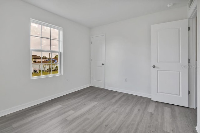 303 Anchovie Ct, Poinciana, FL 34759 - unfurnished bedroom featuring wood finished floors and baseboards