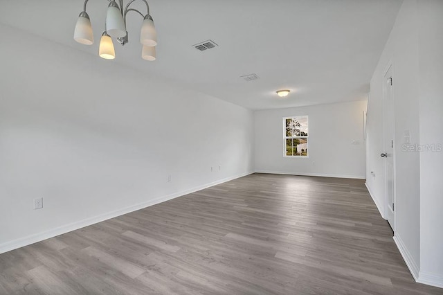 303 Anchovie Ct, Poinciana, FL 34759 - empty room featuring wood finished floors and a chandelier