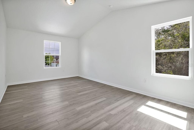 303 Anchovie Ct, Poinciana, FL 34759 - empty room with vaulted ceiling and wood finished floors