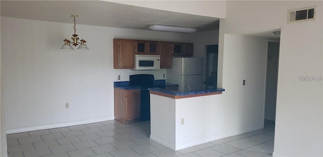 5287 Images Cir Unit 307, Kissimmee, FL 34746 - kitchen with white appliances, dark countertops, a chandelier, light tile patterned floors, and pendant lighting