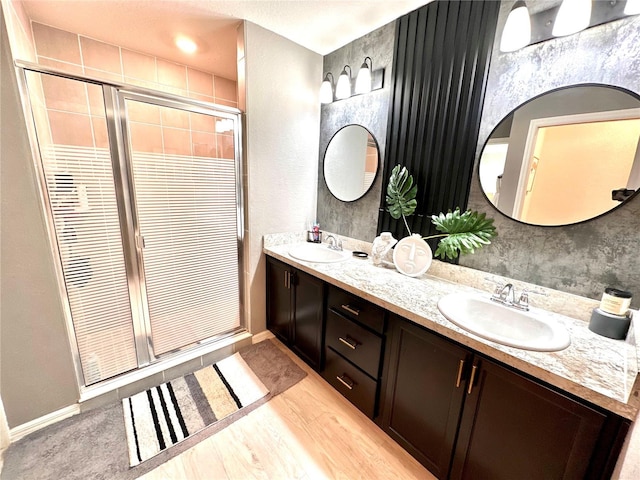 144 Foxtail Loop, Davenport, FL 33837 - bathroom with double vanity, a shower stall, and wood finished floors