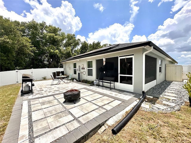 144 Foxtail Loop, Davenport, FL 33837 - back of property with an outdoor fire pit, a patio, a fenced backyard, a gate, and stucco siding
