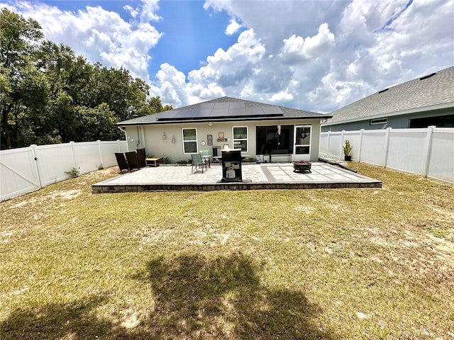 144 Foxtail Loop, Davenport, FL 33837 - back of house featuring roof mounted solar panels, a patio, and a fenced backyard