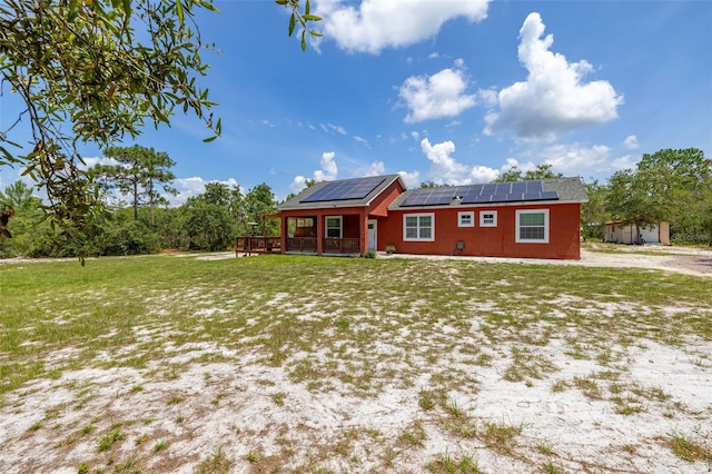 2576 R E Byrd Rd, Frostproof, FL 33843 - view of front of home featuring roof mounted solar panels, a front yard, and a wooden deck
