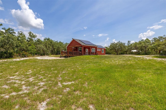 2576 R E Byrd Rd, Frostproof, FL 33843 - view of front of home featuring solar panels, a wooden deck, and a front yard