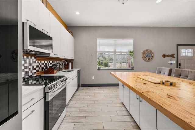 2576 R E Byrd Rd, Frostproof, FL 33843 - kitchen with appliances with stainless steel finishes, tasteful backsplash, recessed lighting, white cabinets, and wood counters
