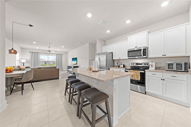 7413 Bent Tree Loop, Saint Cloud, FL 34771 - kitchen with stainless steel appliances, open floor plan, white cabinetry, recessed lighting, and a kitchen island with sink