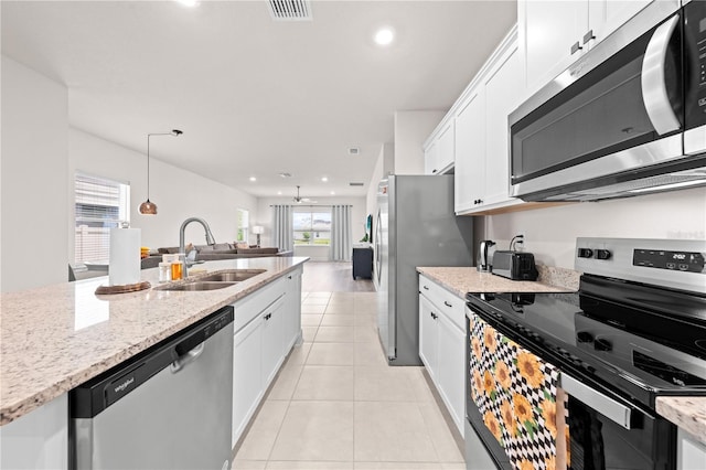 7413 Bent Tree Loop, Saint Cloud, FL 34771 - kitchen featuring stainless steel appliances, white cabinets, healthy amount of natural light, recessed lighting, and light stone counters