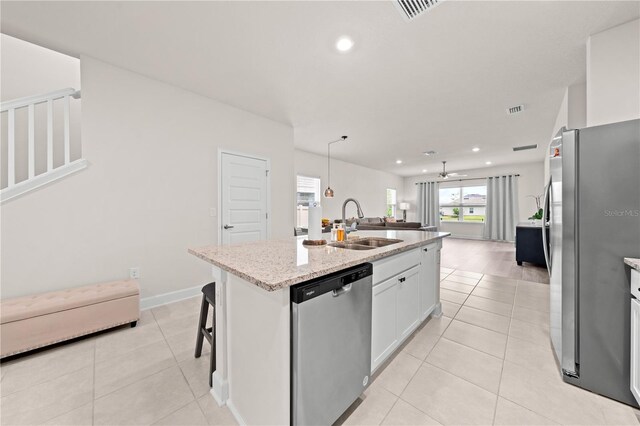 7413 Bent Tree Loop, Saint Cloud, FL 34771 - kitchen featuring stainless steel appliances, open floor plan, recessed lighting, light tile patterned floors, and light stone countertops