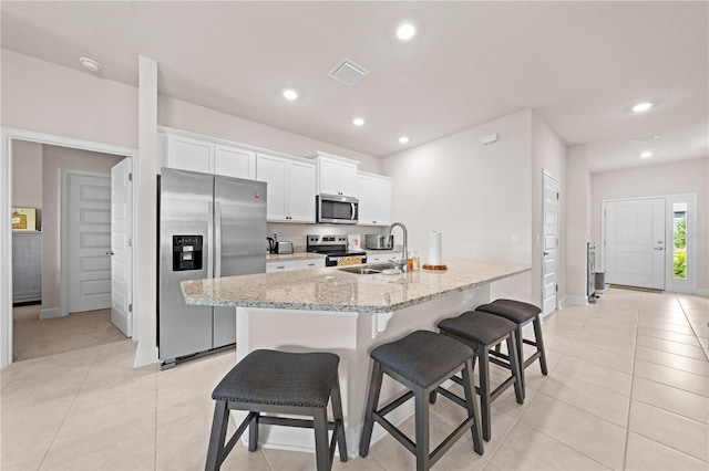 7413 Bent Tree Loop, Saint Cloud, FL 34771 - kitchen featuring appliances with stainless steel finishes, light tile patterned floors, a breakfast bar, white cabinetry, and recessed lighting