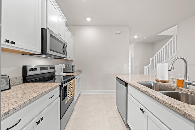 7413 Bent Tree Loop, Saint Cloud, FL 34771 - kitchen with appliances with stainless steel finishes, recessed lighting, white cabinetry, light tile patterned flooring, and light stone counters
