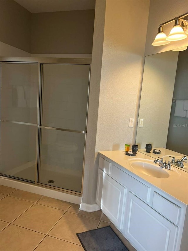 4862 Cayview Ave Unit 40409, Orlando, FL 32819 - bathroom featuring tile patterned flooring, vanity, a shower stall, and a textured wall
