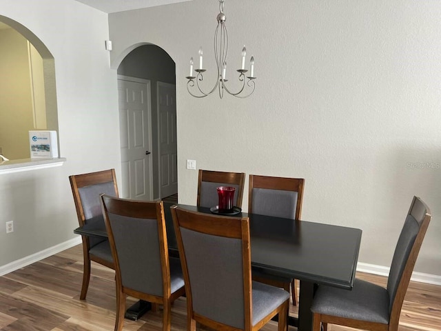 4862 Cayview Ave Unit 40409, Orlando, FL 32819 - dining space featuring arched walkways, wood finished floors, and a chandelier