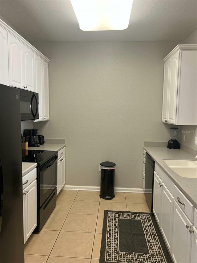 4862 Cayview Ave Unit 40409, Orlando, FL 32819 - kitchen with black appliances, white cabinets, light tile patterned floors, and light countertops