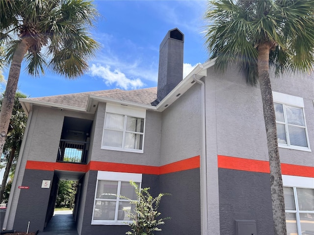 3100 Parkway Blvd Unit 521, Kissimmee, FL 34747 - view of home's exterior featuring stucco siding, a chimney, and roof with shingles