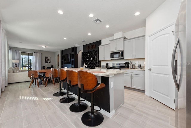 11051 Bostwick Aly, Winter Garden, FL 34787 - kitchen featuring stainless steel appliances, an island with sink, recessed lighting, open floor plan, and a breakfast bar