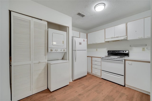 3205 Sabal Palms Ct Unit A, Kissimmee, FL 34747 - kitchen featuring white appliances, stacked washer / drying machine, under cabinet range hood, white cabinetry, and light countertops