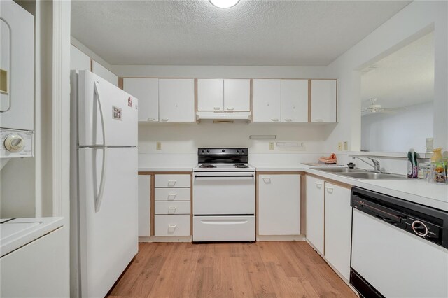 3205 Sabal Palms Ct Unit A, Kissimmee, FL 34747 - kitchen with white appliances, under cabinet range hood, stacked washer and clothes dryer, white cabinetry, and light countertops