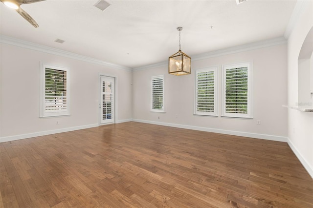 502 Mirasol Cir Unit 103, Kissimmee, FL 34747 - empty room featuring plenty of natural light, wood finished floors, ornamental molding, and arched walkways