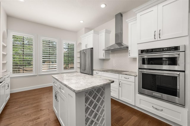 502 Mirasol Cir Unit 103, Kissimmee, FL 34747 - kitchen with wall chimney exhaust hood, stainless steel appliances, white cabinetry, dark wood finished floors, and recessed lighting
