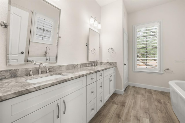 502 Mirasol Cir Unit 103, Kissimmee, FL 34747 - full bathroom with a freestanding bath, double vanity, and wood finished floors