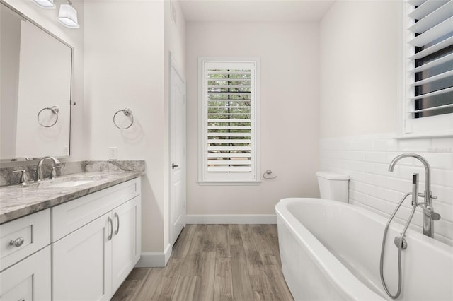 502 Mirasol Cir Unit 103, Kissimmee, FL 34747 - full bathroom featuring vanity, a soaking tub, and wood finished floors