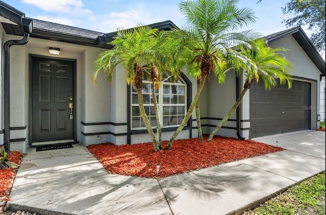 6528 Shepherd Oaks Pass, Lakeland, FL 33811 - view of exterior entry with stucco siding, a garage, and concrete driveway