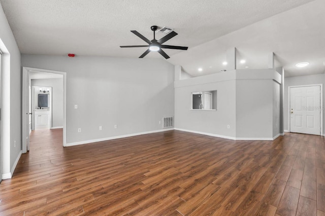 6528 Shepherd Oaks Pass, Lakeland, FL 33811 - unfurnished living room with a ceiling fan, dark wood finished floors, vaulted ceiling, and a textured ceiling