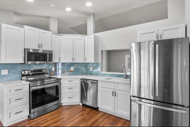 6528 Shepherd Oaks Pass, Lakeland, FL 33811 - kitchen with stainless steel appliances, light countertops, white cabinets, tasteful backsplash, and dark wood-style flooring