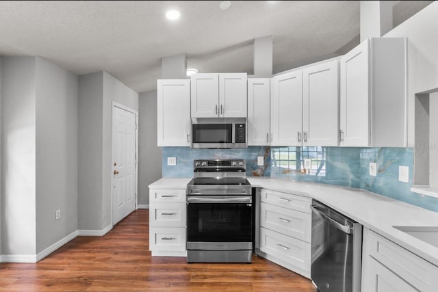 6528 Shepherd Oaks Pass, Lakeland, FL 33811 - kitchen with stainless steel appliances, light countertops, decorative backsplash, wood finished floors, and recessed lighting