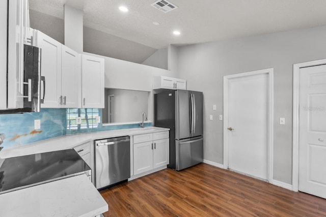 6528 Shepherd Oaks Pass, Lakeland, FL 33811 - kitchen with appliances with stainless steel finishes, dark wood-type flooring, white cabinetry, recessed lighting, and vaulted ceiling