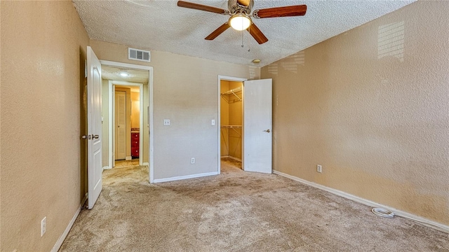 5112 Conroy Rd Unit 24, Orlando, FL 32811 - unfurnished bedroom with a textured ceiling, a textured wall, a walk in closet, carpet flooring, and ceiling fan