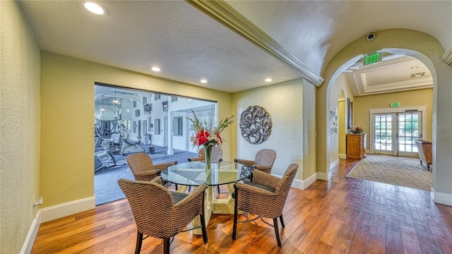 5112 Conroy Rd Unit 24, Orlando, FL 32811 - dining space featuring arched walkways, a textured wall, french doors, hardwood / wood-style floors, and recessed lighting