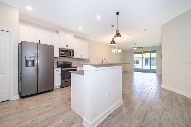 1173 Trappers Trail Loop, Champions Gate, FL 33896 - kitchen with appliances with stainless steel finishes, light wood-style flooring, white cabinetry, a center island with sink, and recessed lighting