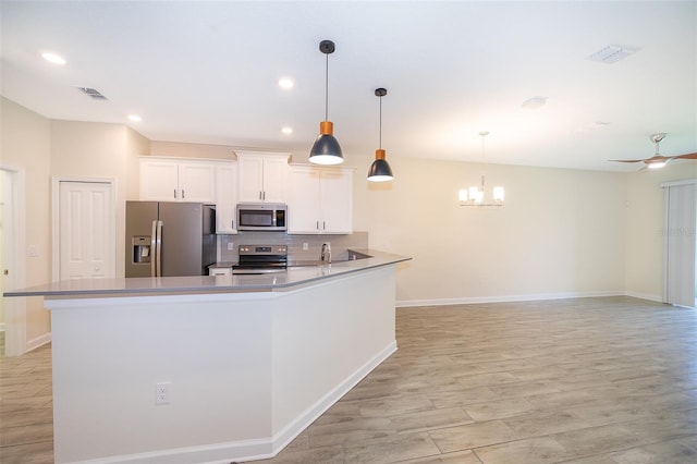 1173 Trappers Trail Loop, Champions Gate, FL 33896 - kitchen featuring stainless steel appliances, white cabinets, decorative backsplash, a peninsula, and a chandelier