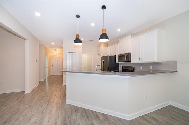 1173 Trappers Trail Loop, Champions Gate, FL 33896 - kitchen with stainless steel appliances, light wood-type flooring, white cabinets, backsplash, and decorative light fixtures