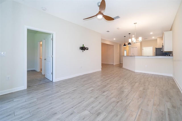 1173 Trappers Trail Loop, Champions Gate, FL 33896 - unfurnished living room featuring light wood-style flooring, a ceiling fan, a chandelier, and recessed lighting