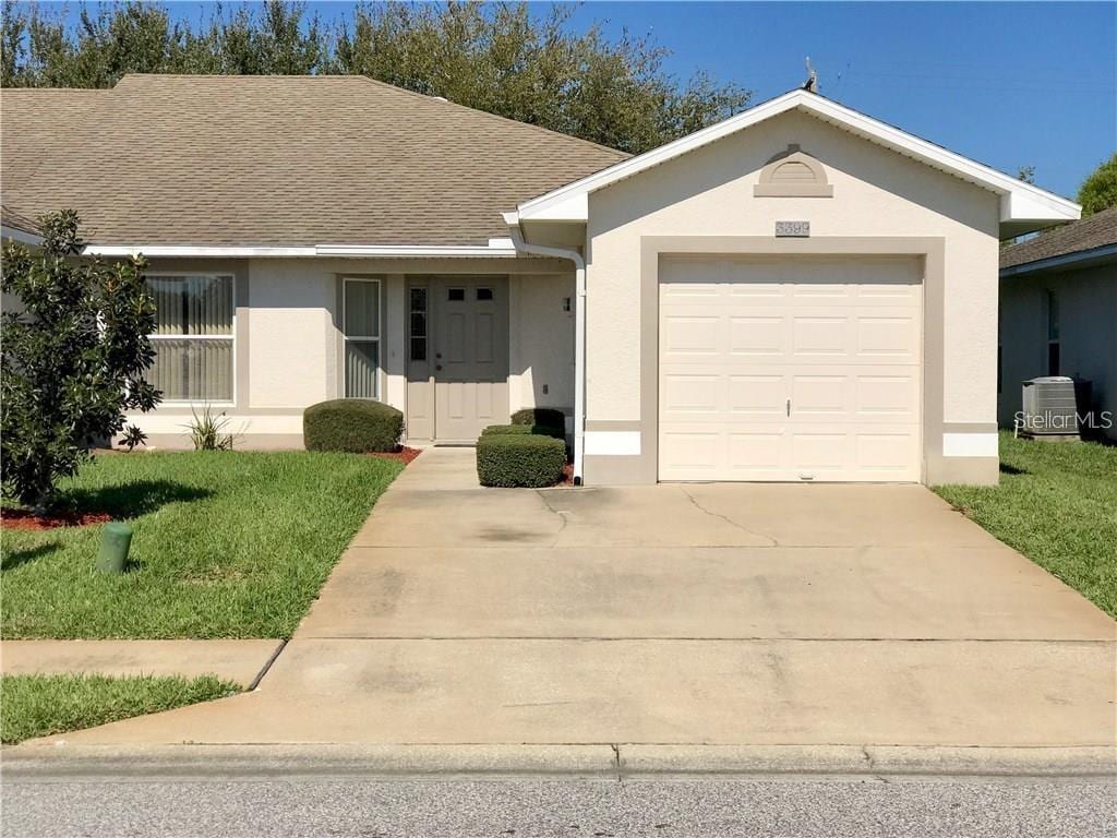 3399 Celena Cir, Saint Cloud, FL 34769 - ranch-style house featuring concrete driveway, a garage, stucco siding, and a front yard
