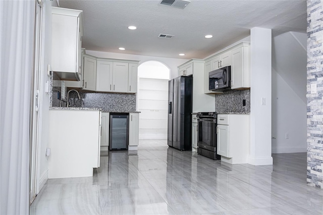 1101 Sandestin Way, Orlando, FL 32824 - kitchen with black appliances, beverage cooler, decorative backsplash, light stone counters, and recessed lighting