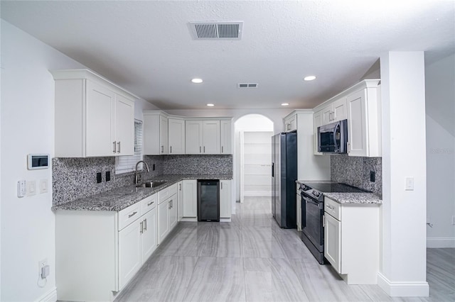 1101 Sandestin Way, Orlando, FL 32824 - kitchen with appliances with stainless steel finishes, stone counters, wine cooler, backsplash, and recessed lighting