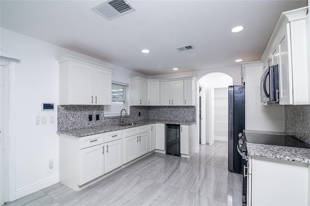 1101 Sandestin Way, Orlando, FL 32824 - kitchen with wine cooler, electric range, arched walkways, freestanding refrigerator, and tasteful backsplash
