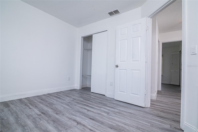 1101 Sandestin Way, Orlando, FL 32824 - unfurnished bedroom with wood finished floors, a closet, and a textured ceiling