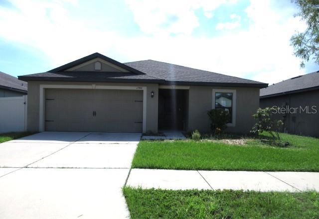 1740 Chatham Green Cir, Ruskin, FL 33570 - single story home with stucco siding, a garage, driveway, and a front yard