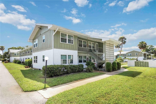 840 Center Ave Unit 80, Daytona Beach, FL 32117 - rear view of property featuring board and batten siding, a yard, and stairs