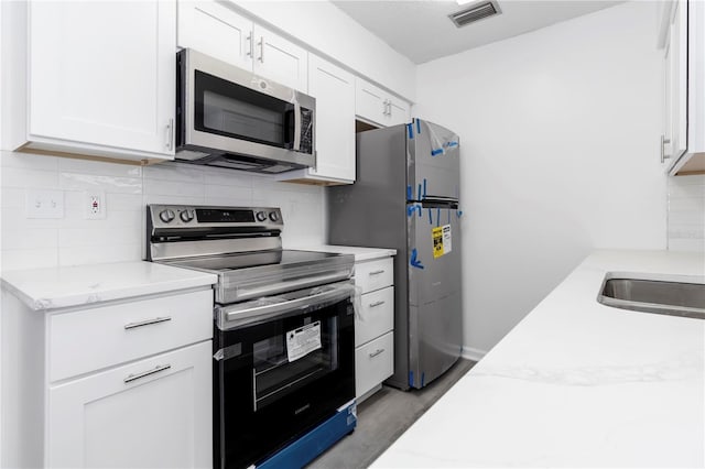 840 Center Ave Unit 80, Daytona Beach, FL 32117 - kitchen with appliances with stainless steel finishes, backsplash, white cabinets, and wood finished floors