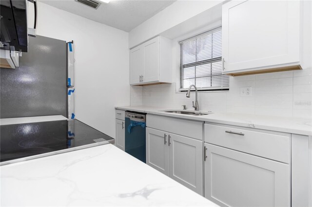 840 Center Ave Unit 80, Daytona Beach, FL 32117 - kitchen with dishwashing machine, tasteful backsplash, white cabinets, and light stone countertops